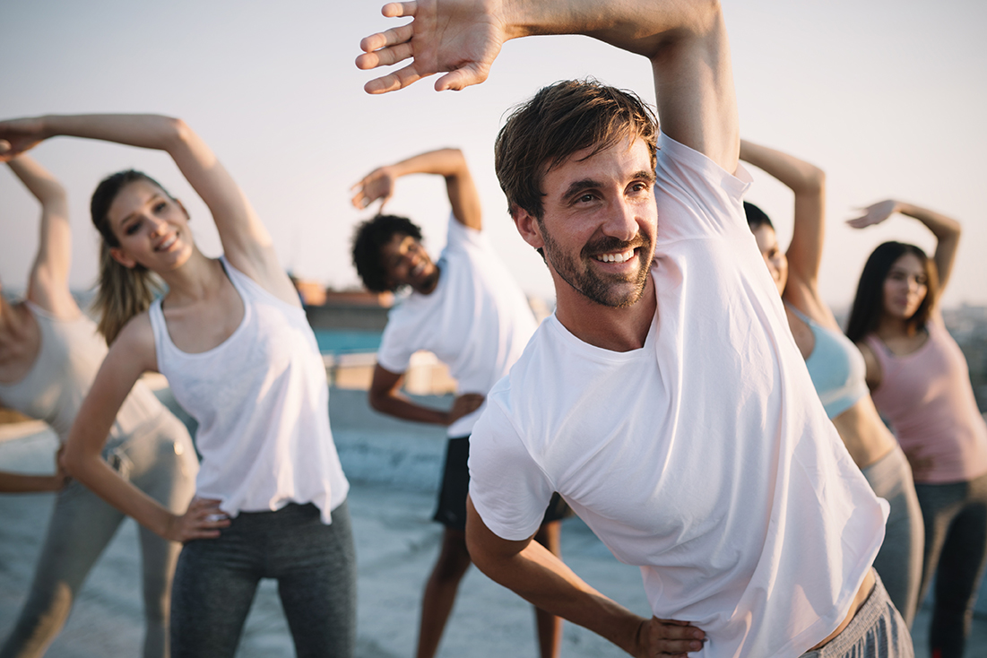 Fitness, sport, friendship and healthy lifestyle concept . Group of happy people exercising
