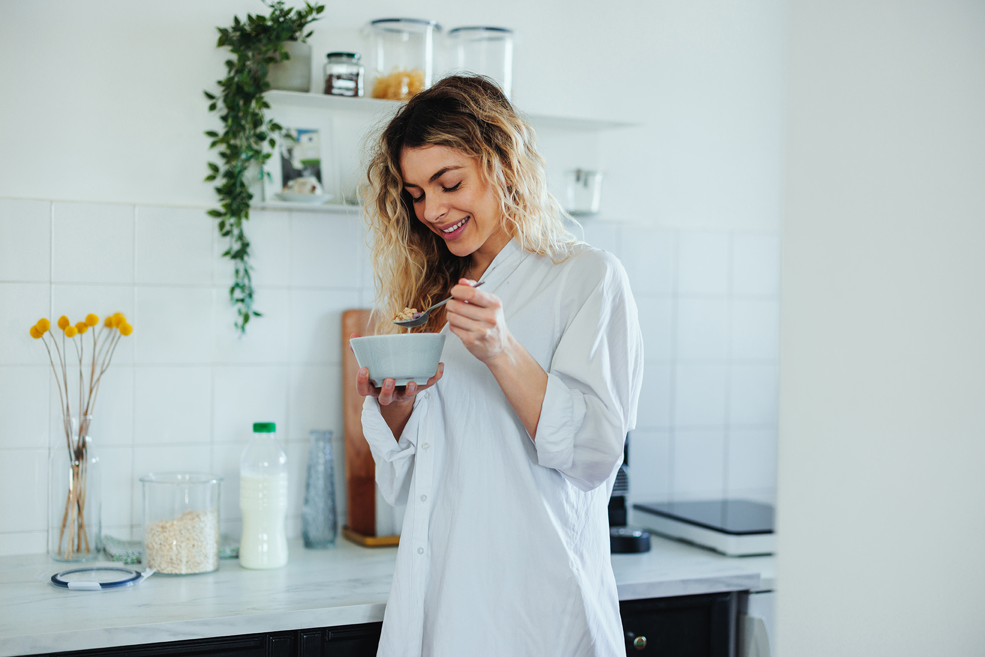 Woman at home eating a bowl of cereals for breakfast